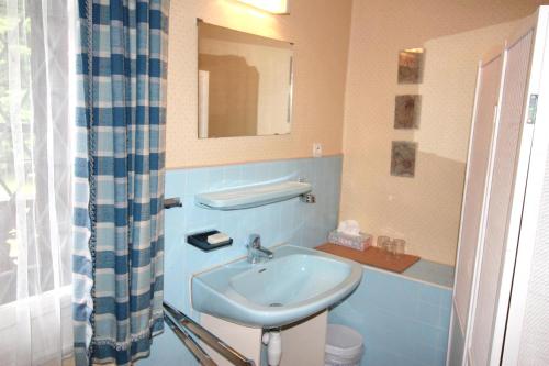a blue bathroom with a sink and a mirror at Maison de charme avec jardin à Mitzach, vue sur montagne in Mitzach