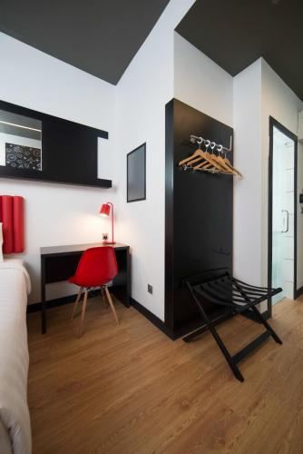 a room with a desk and a red chair at Kalya Hotel Bandung Dago in Bandung