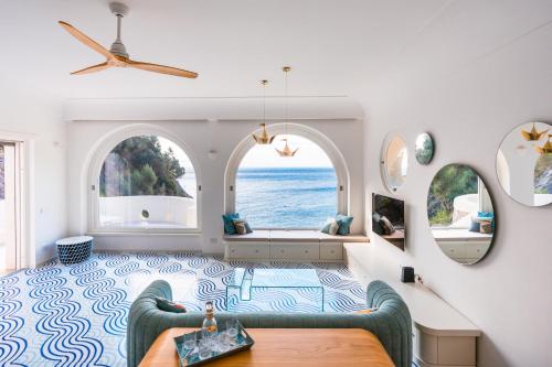a living room with a couch and two windows at Acquachiara Seaside Luxury Villa in Amalfi Coast in Maiori