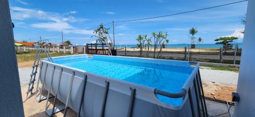 a swimming pool on a balcony with a view of the beach at Kamalia Villas in Kampung Penarik