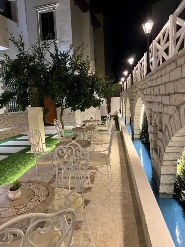 a row of tables and chairs next to a bridge at Hotel Mimani in Berat