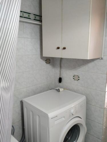 a white washing machine in a bathroom with a cabinet at Central Kiato in Kiáton