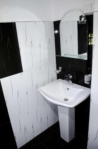 a bathroom with a white sink and a mirror at Suwa Arana Resort in Mirissa