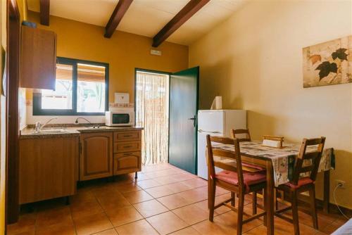 a kitchen with a table and chairs and a refrigerator at Camping Playa La Bota in Punta Umbría