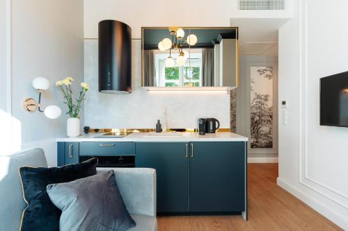 a kitchen with blue cabinets and a sink at Warsaw Story - LoftAffair Collection in Warsaw
