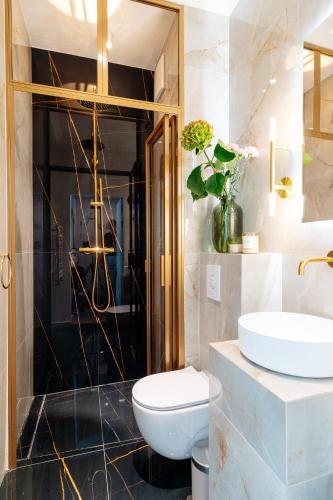 a bathroom with a toilet and a sink at Warsaw Story - LoftAffair Collection in Warsaw