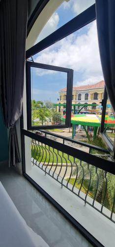 a balcony with a window with a view of a park at BREAKING DAWN- TAEYANG Hotel Phú Quốc in Phu Quoc