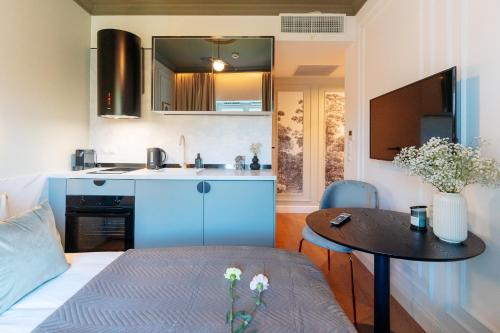 a small living room with a table and a kitchen at Warsaw Story - LoftAffair Collection in Warsaw