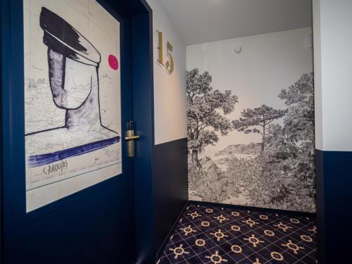 a room with a blue door with a painting on the wall at HOTEL LA MARINE in Groix