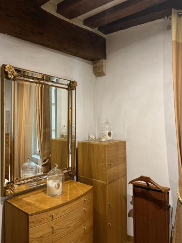 Cette chambre comprend une commode et un miroir mural. dans l'établissement Quartier Montorgueil, voie piétonne, dans un immeuble du XVème, à Paris