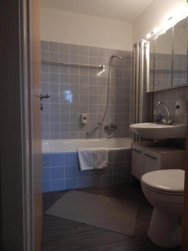 uma casa de banho com uma banheira, um lavatório e um WC. em Appartement zur Bergoase mi Schwimmbad em Hohegeiß