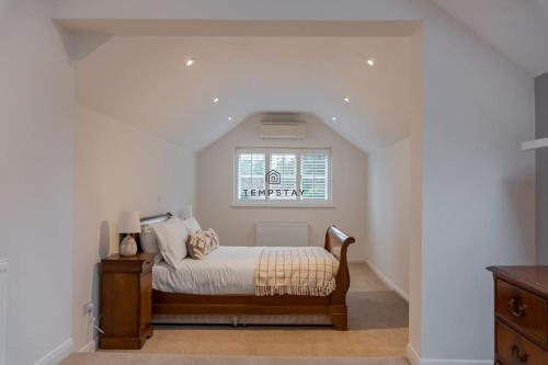 a bedroom with a bed and a window at Cosy Family Home Near Thorpe Park & Legoland in Old Windsor