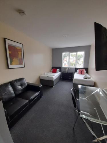 a living room with a couch and a chair at Lymedale Suites Studios & Aparthotel in NEWCASTLE UNDER LYME & STOKE in Newcastle under Lyme