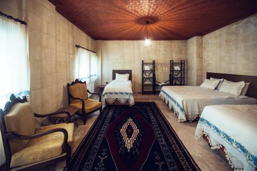 um quarto com duas camas e uma cadeira em Azalea Terrace Hotel em Goreme
