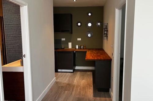 een keuken met zwarte apparatuur en een houten vloer bij Lovely 1-bedroom apartment in London N1 in Londen