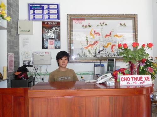 a person sitting at a desk in a office at Minh Tai Hotel in Mỹ Tho
