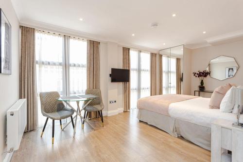 伦敦Cleveland Residences Farringdon的一间带床、桌椅的酒店房间