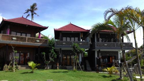 a resort with two story buildings with palm trees at Gubug Balian Beach Bungalow in Selemadeg