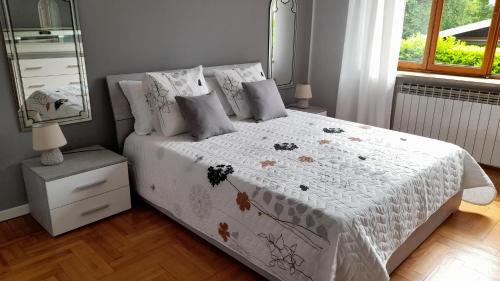 a bedroom with a bed with a white comforter and a mirror at Casa Germana in Invorio Inferiore