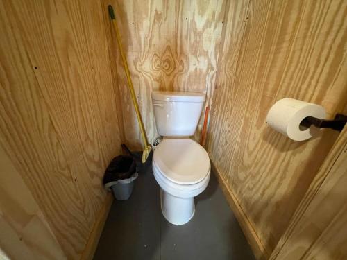 a bathroom with a toilet in a wooden wall at Reflection Cabin on Lake Godstone in Jacksboro