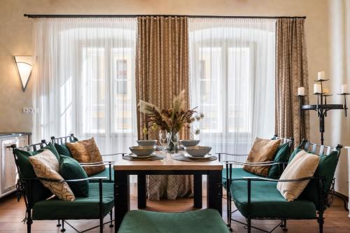 a dining room with a table and green chairs at Boutique hotel Soukeníkův dům in Kutná Hora