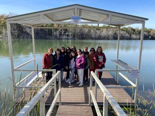 a group of women standing on a dock on a lake at Reflection Cabin on Lake Godstone in Jacksboro