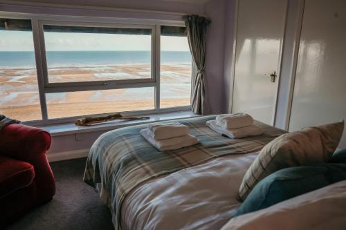 a bedroom with a bed and a window with towels on it at 14 Burnett House by Prestige Properties SA in Seascale