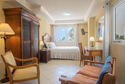 een kamer met een slaapkamer met een bed en een bureau bij Bay Harbor Luxury 1 bedroom apartments in Oranjestad