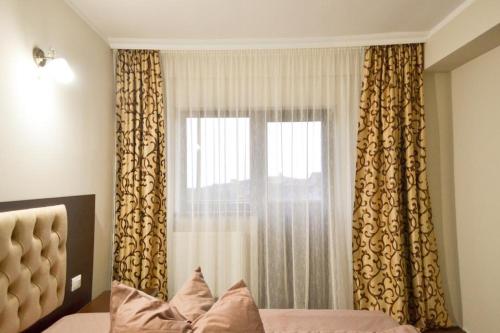 a bedroom with a bed and a window with curtains at Cabana Bella Vista in Ranca