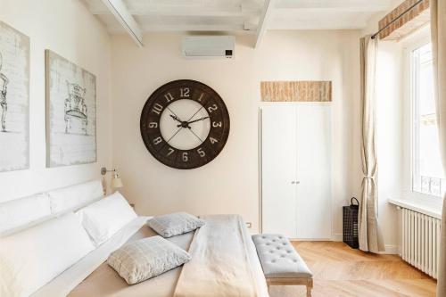 THE BREAK - VIA FRATTINA MAISON DELUXE في روما: غرفة معيشة مع ساعة كبيرة على الحائط