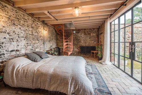 a bedroom with a bed and a brick wall at The Limes Benhall - Air Manage Suffolk in Saxmundham