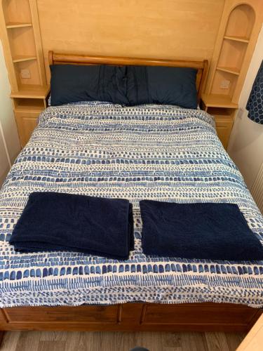 a bed with two pillows on it in a room at Postwood Gardens Balmoral Country Cabin in Kentisbeare