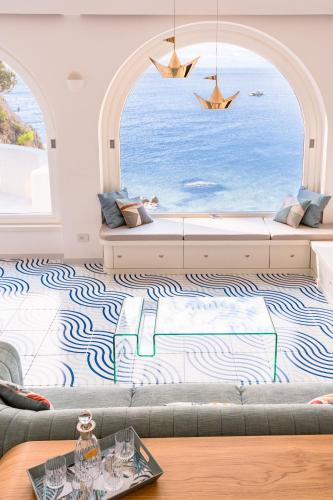 a living room with a couch and a large window at Acquachiara Seaside Luxury Villa in Amalfi Coast in Maiori