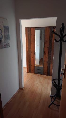 ein leeres Zimmer mit einem Spiegel und einem Holzboden in der Unterkunft Bella Casa1 in Leipzig