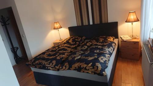 ein Schlafzimmer mit einem Bett, zwei Lampen und einem Telefon in der Unterkunft Bella Casa1 in Leipzig