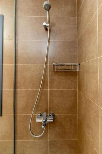 a shower with a shower head in a bathroom at SOL Y PLAYA El Cotillo beachfront with pool & ocean views in El Cotillo