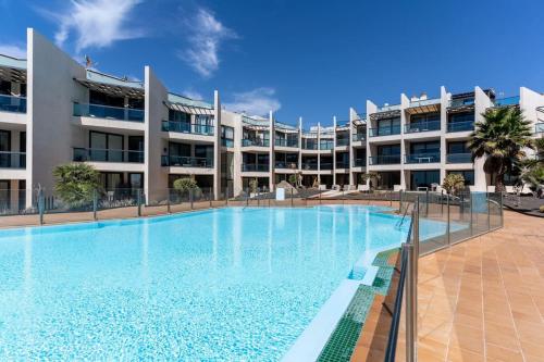 a large swimming pool in front of a building at Appartamento SOL Y PLAYA a El Cotillo. in Cotillo