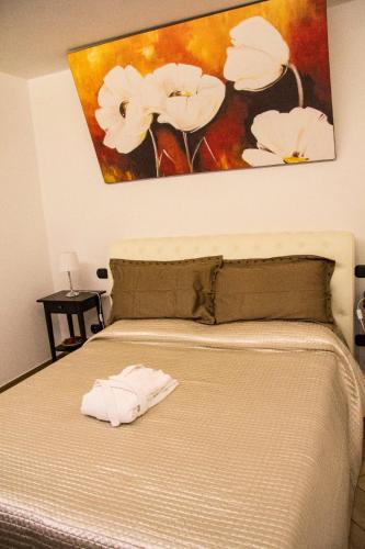a bedroom with a bed with a painting on the wall at Little House in Modugno