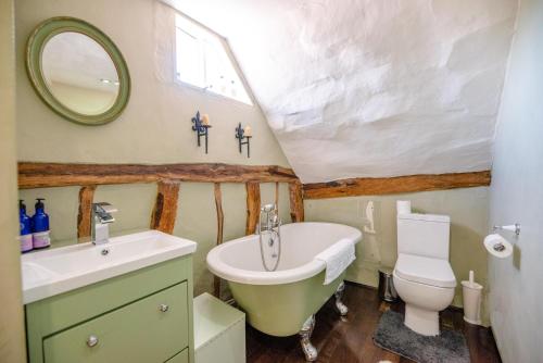 y baño con lavabo, bañera y aseo. en Bridge House in Kersey, en Ipswich