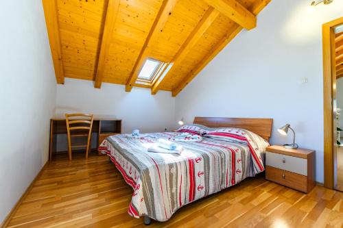 a bedroom with a bed and a wooden floor at Apartman Marina in Martinšćica