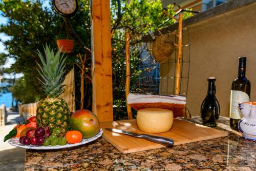 a table with a plate of fruit and a cutting board at Apartman Marina in Martinšćica