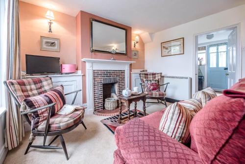 a living room with a couch and a fireplace at The Bolt Hole in Southwold in Southwold