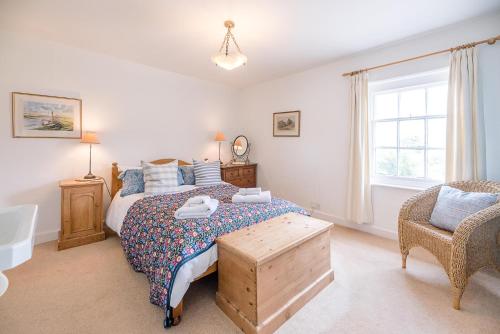 a bedroom with a bed and a chair and a window at The Bolt Hole in Southwold in Southwold