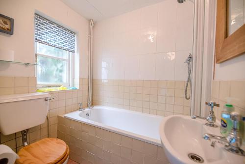 a bathroom with a tub and a sink and a toilet at The Bolt Hole in Southwold in Southwold
