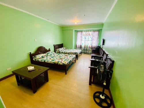- un salon avec deux lits et une table dans l'établissement Albergo Hotel - Studio Condo Unit - Baguio Transient, à Baguio