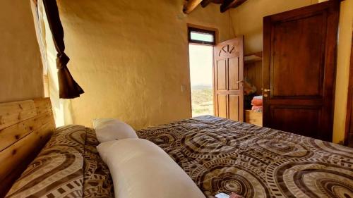 um quarto com uma cama num quarto com uma janela em CABAÑAS KONDUR Elementos em Luján de Cuyo