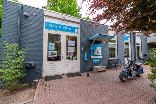 a scooter parked in front of a store at Comfort Rooms by EuroParcs De Hooge Veluwe in Arnhem