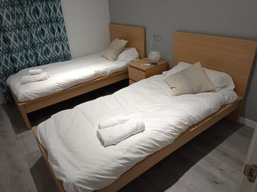 Dos camas en una habitación con toallas. en Brand new charming apartment next to the river, en Sevilla