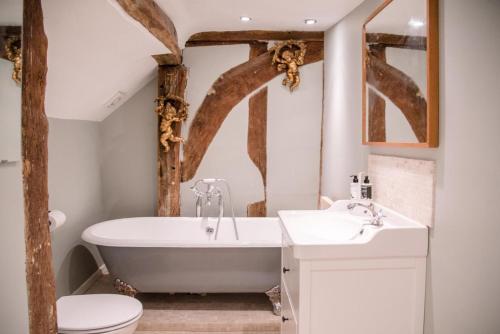 y baño con bañera, aseo y lavamanos. en Rose Cottage in Lavenham, en Lavenham