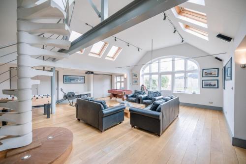a living room with a spiral staircase in a loft at The Links in Southwold in Southwold